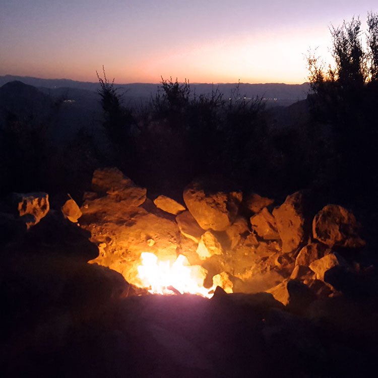 Campfire with background of Flagstaff, Arizona during sunset